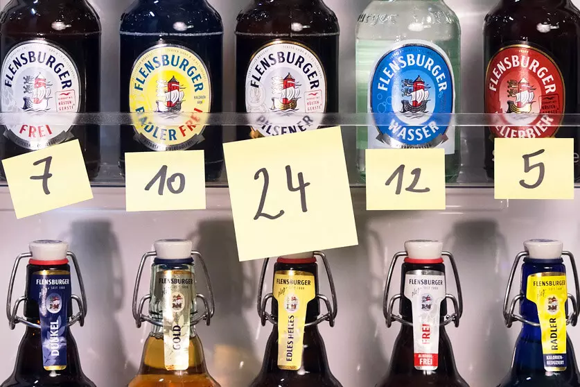 Flensburger Bierflaschen mit Zetteln versehen, auf denen Nummern stehen.