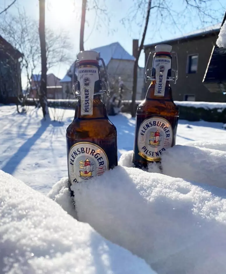 Zwei FLENS Flaschen im Schnee.