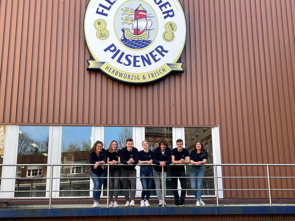 Die Gruppe der Guides für die Brauereibesichtigung steht vor der Flensburger Brauerei.