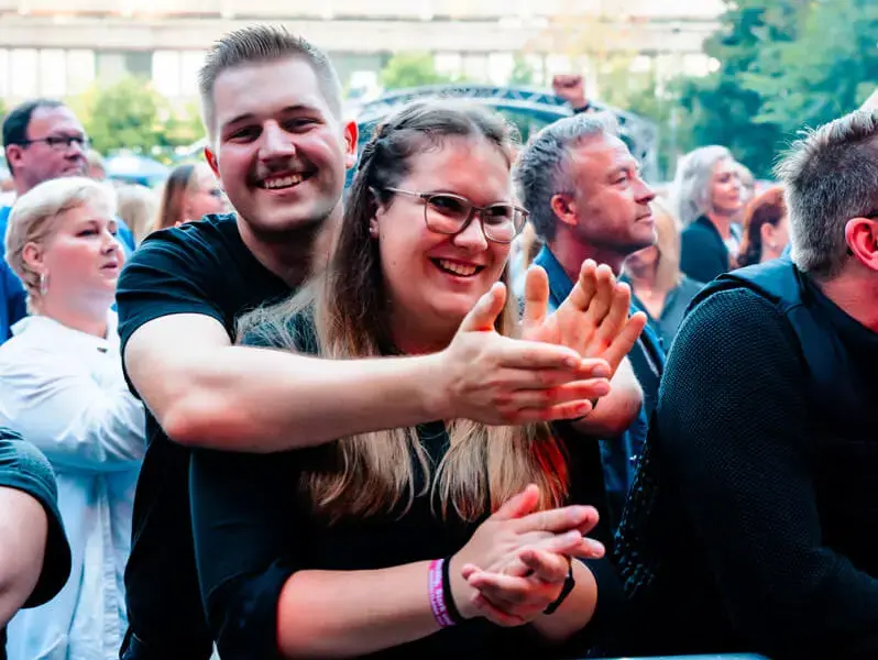 Fröhliches Pärchen im Publikum beim FLENS Festival 2025 am Mitklatschen.