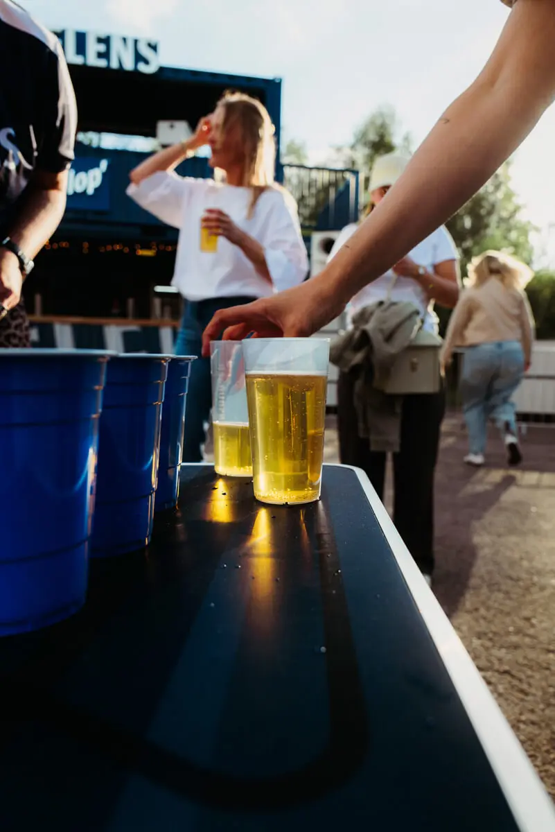 Beer-Pong-Tisch mit blauen Plastikbechern und FLENS Bier beim Butcher-Jam-Festival 2026.