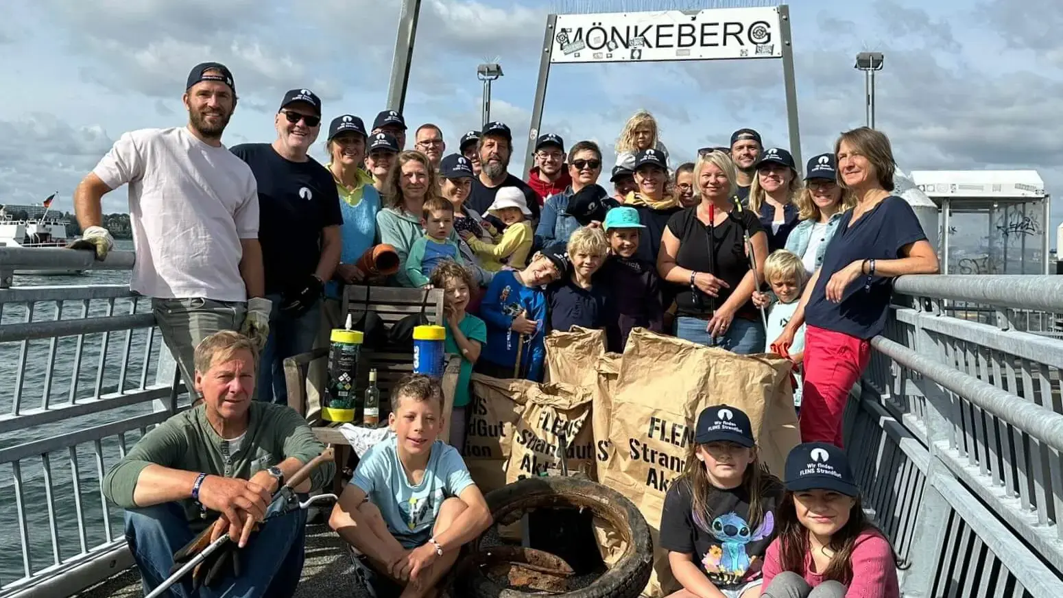 Gruppe von Menschen bei einer FLENS Strandreinigungsaktion in Mönkeberg.