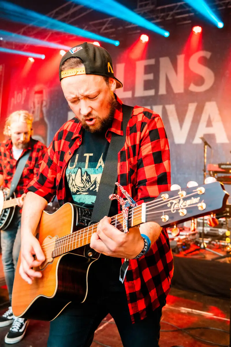 Mitglied der Partyband Die Andersons an der Gitarre auf dem FLENS Festival 2025.