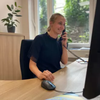 Azubi telefonierend am Schreibtisch