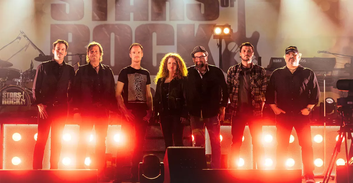 Pressebild der Coverband The Stars of Rock: 7 Bandmitglieder auf der Bühne, vorne rote Scheinwerfer.