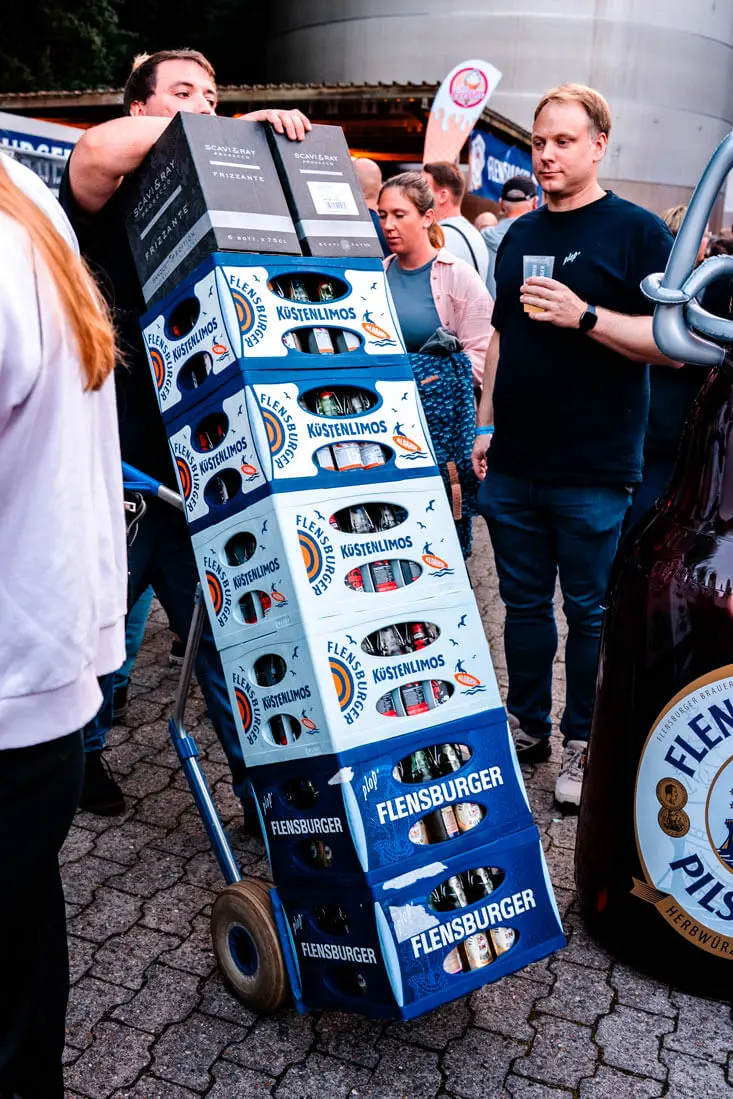 Servicekraft auf dem FLENS Festival 2025 beim Transport der Getränkekisten.