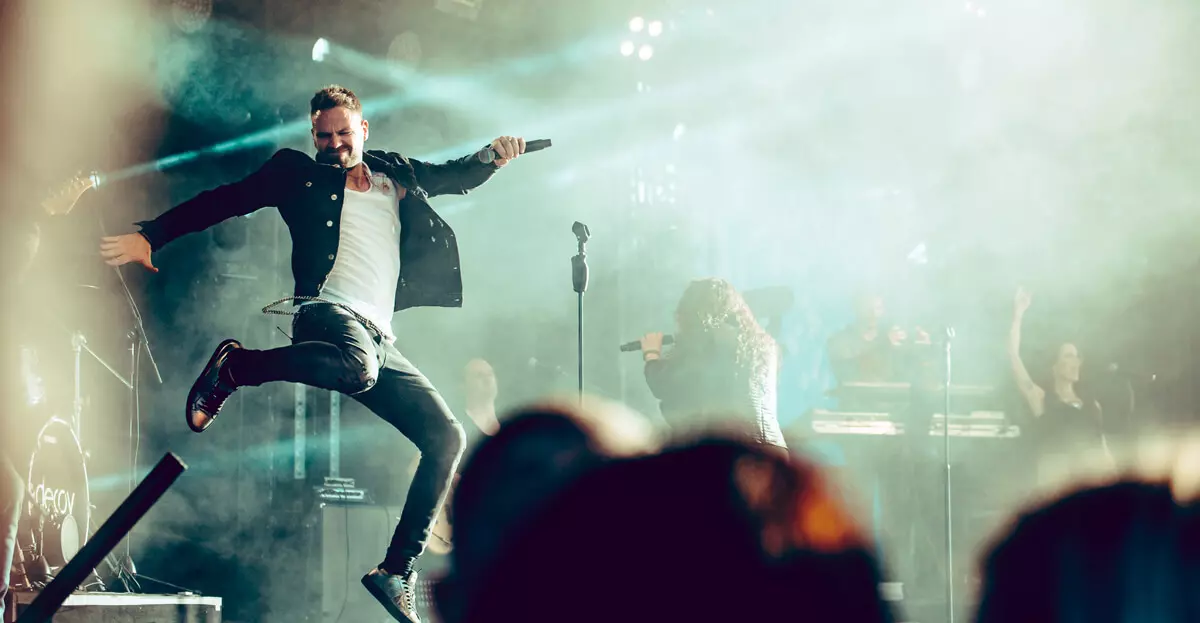 Pressebild der Coverband DECOY: Mann springt dynamisch auf der Bühne.