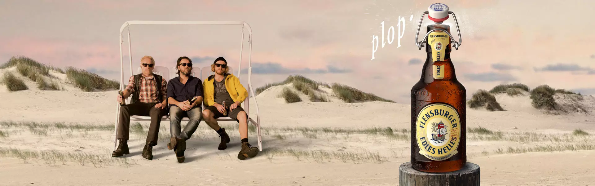 Drei Männer auf einer Schaukel am Strand, Flensburger Edles Helles rechts im Bild.