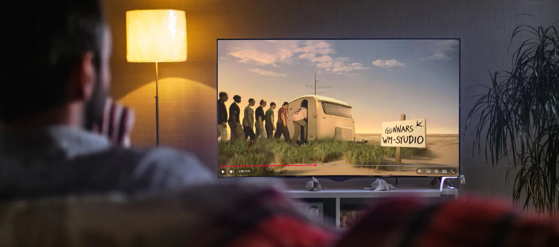 Ein Mann schaut im Wohnzimmer eine alte Flensburger-Werbung auf YouTube an.