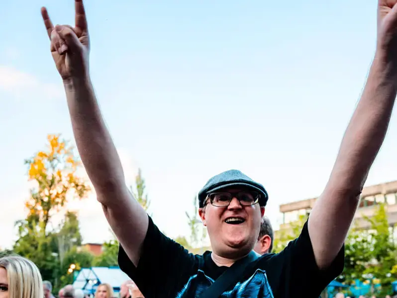 Mann im Publikum beim FLENS Festival 2025 zeigt die Rocker-Pose.