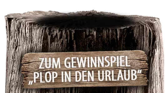 Holzpoller mit Schild vorne: "ZUM GEWINNSPIEL: "PLOP IN DEN URLAUB"."