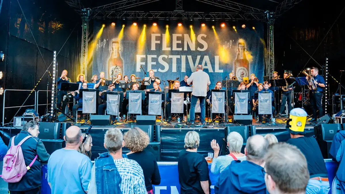 Blick auf die Bühne beim FLENS Festival 2025, während die Flensburger Stadtbläser spielen.