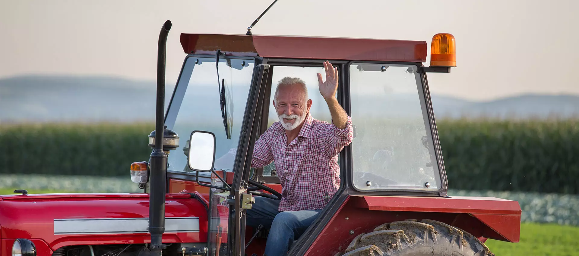 Ein Mann in einem Traktor, der winkt.