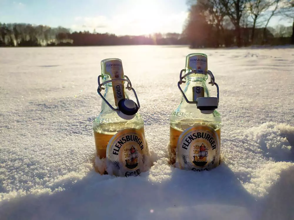 Zwei Flaschen Flensburger Gold im Schnee.