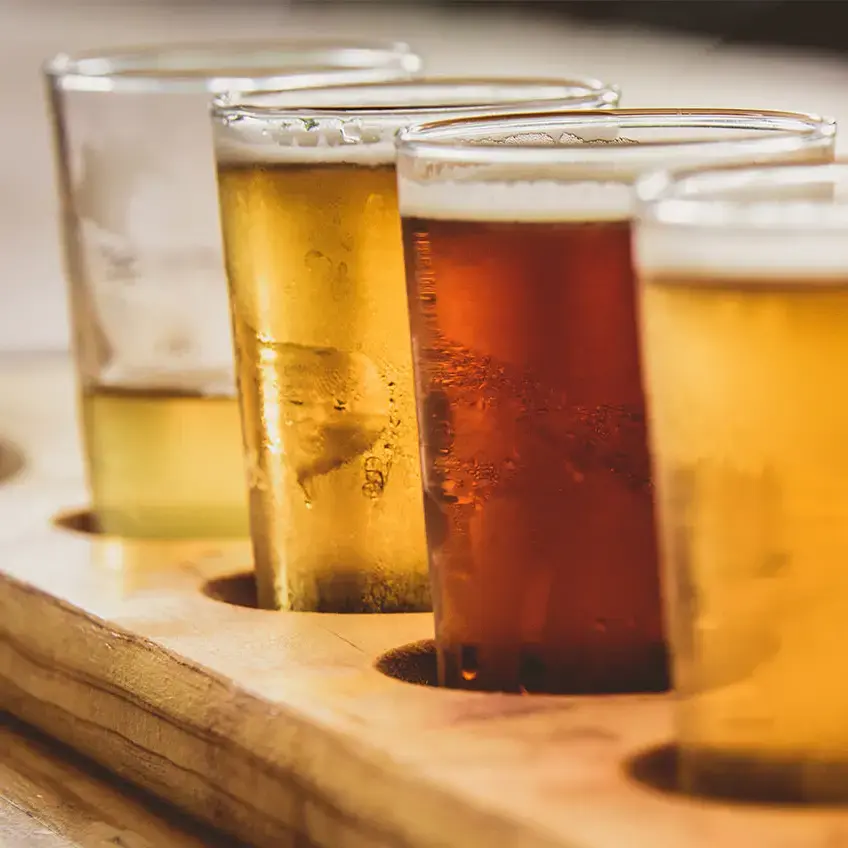 Verschiedene Biere auf einem Servierbrett für Bier.