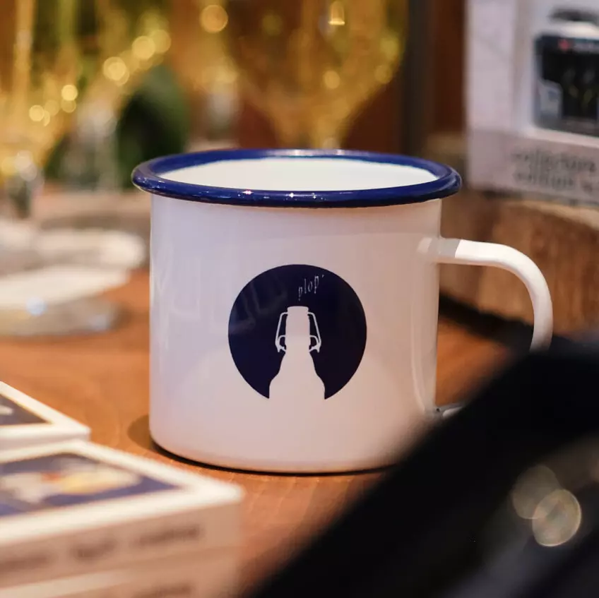 Emailletasse mit dem FLENS Nordlicht im Fokus.