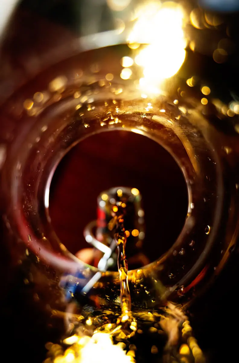 Blick von unten, wie die Küstencola in ein Glas eingeschenkt wird.