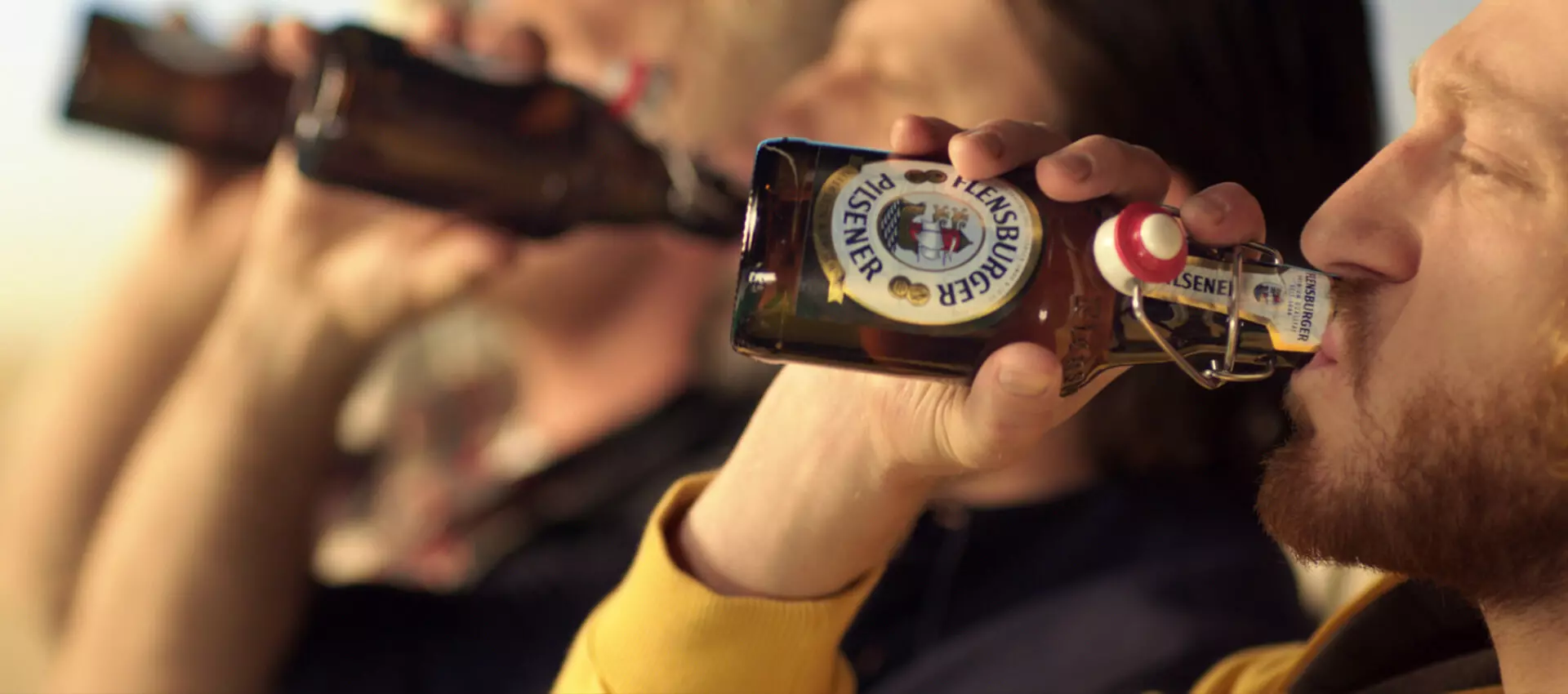 Drei Männer die Flensburger Pilsener trinken. 