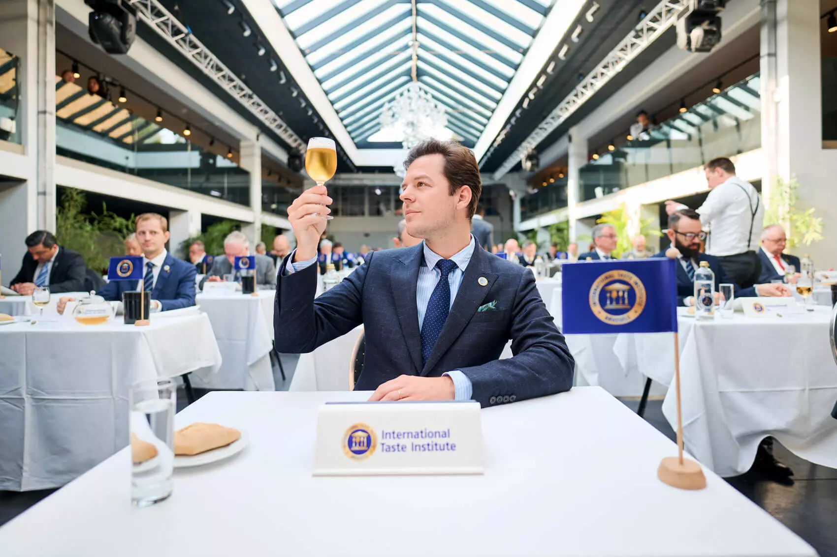 Gabi Lucas, bester Sommelier Spaniens 2021, hält das Flensburger Pilsener gegens Licht bei der Verköstigung beim International Taste Institute.