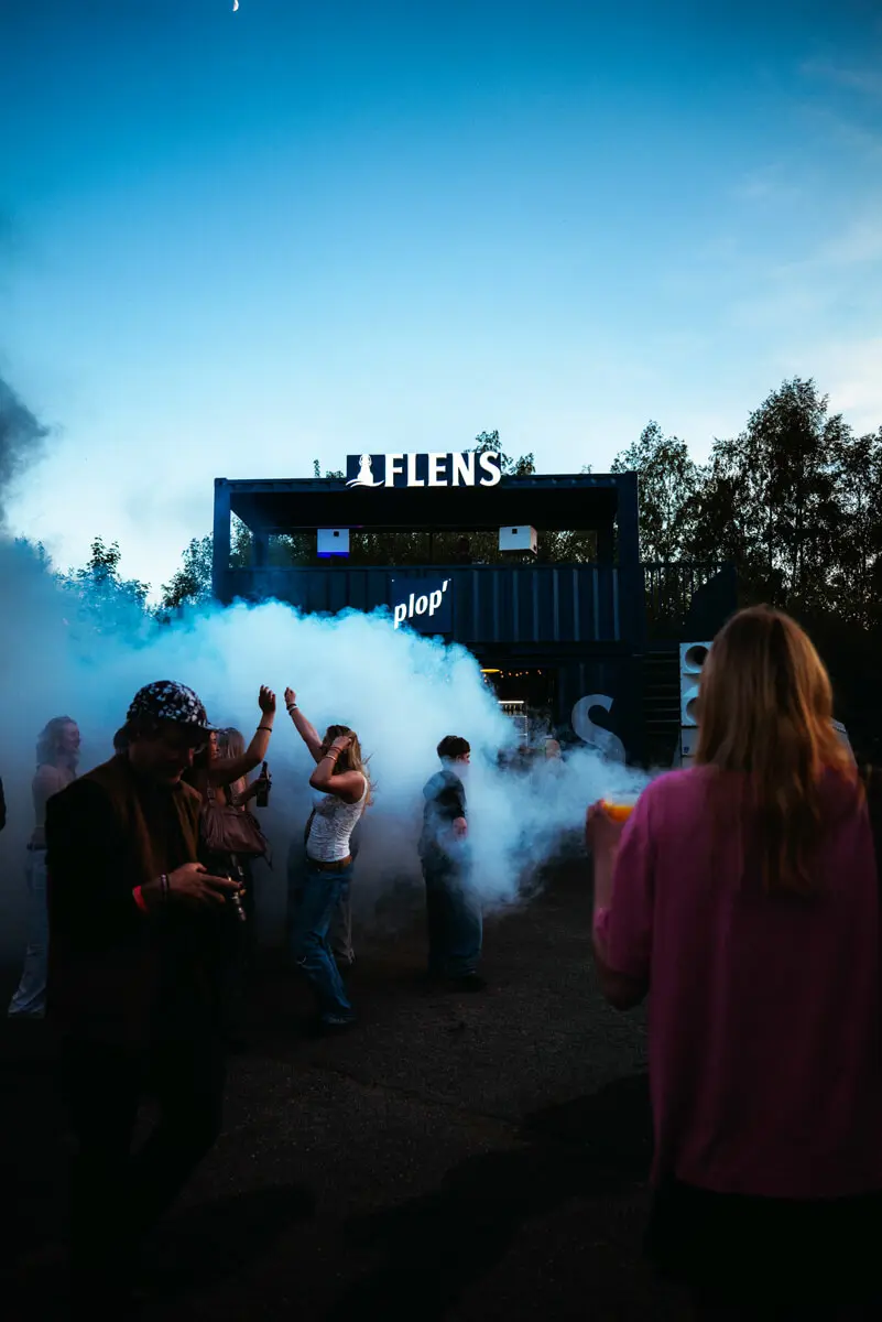 Butcher-Jam-Festival 2026 bei Abenddämmerung mit Nebel, tanzenden Menschen vor FLENS Containerbar.