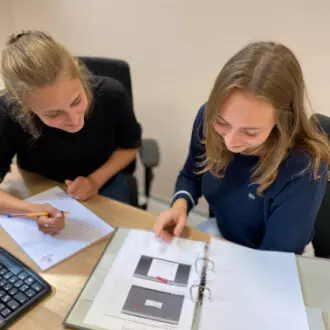 Zwei Personen am Schreibtisch mit Unterlagen