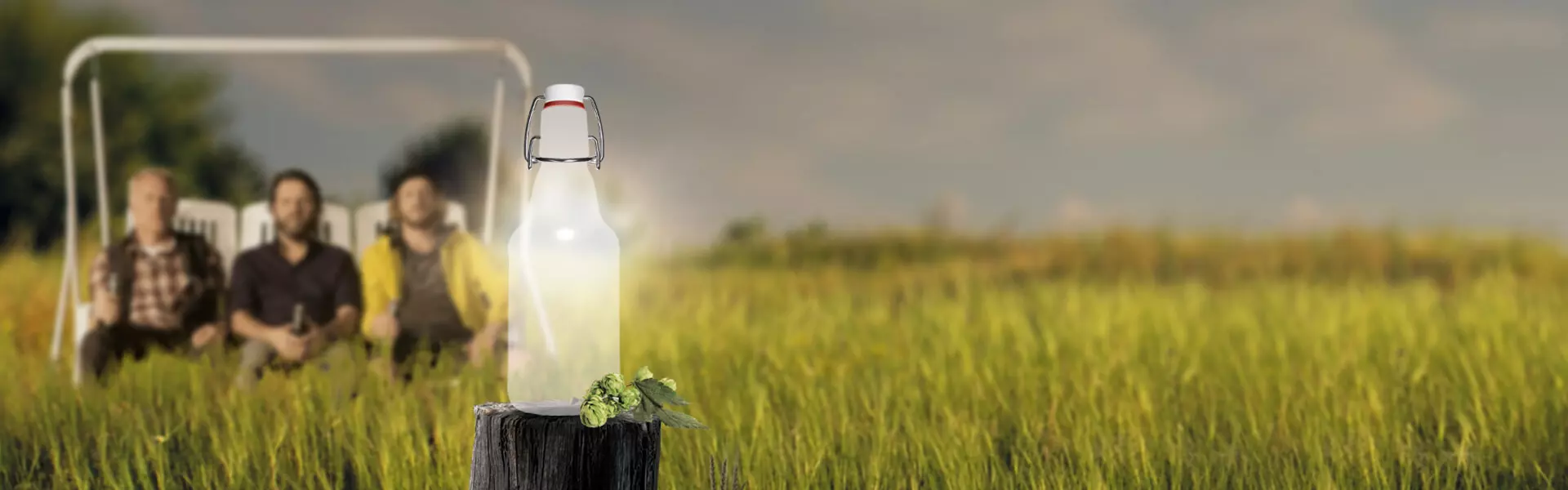 Leere FLENS Flasche vor einer Wiese Jungs auf der Schaukel im Hintergrund