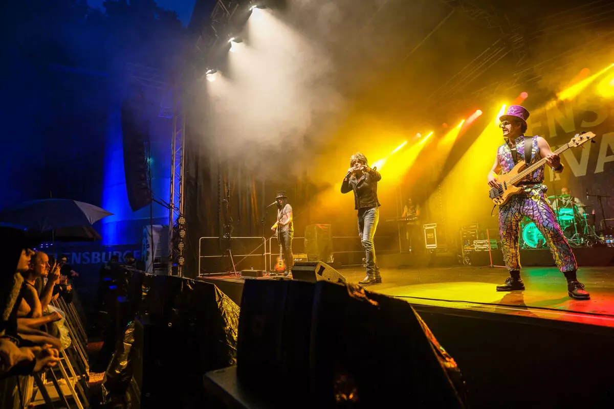 Die kostümierte Coverband "Hit Radio Show" auf der Bühne beim FLENS Festival 2023.
