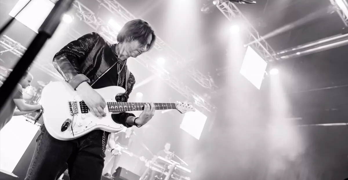 Pressebild der Coverband DECOY in Schwarzweiß: Gitarrist spielt auf einer E-Gitarre.