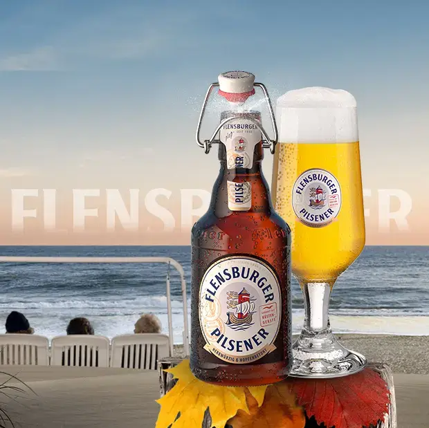Beach scenery with wooden pole in the foreground, carrying a bottle and a glass of Flensburger Pilsener beer.