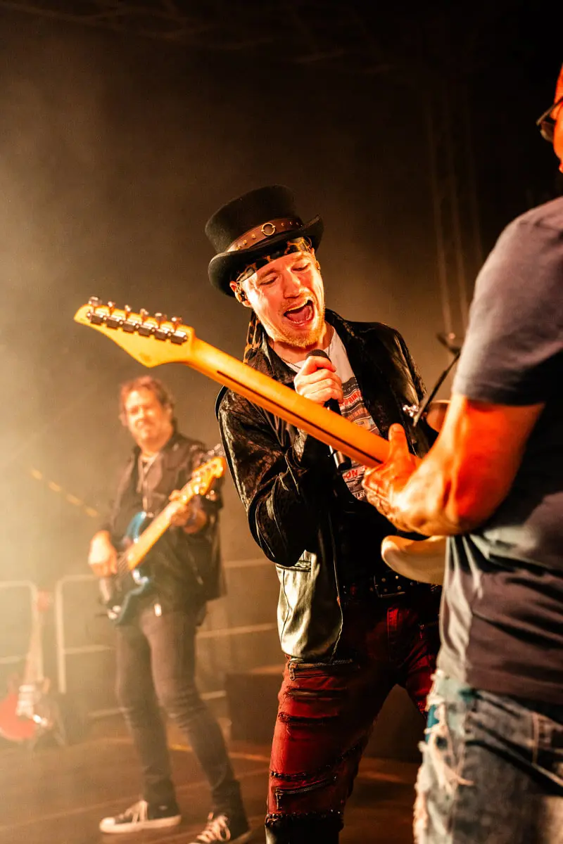 Sänger und im Anschnitt ein Gitarrist der Partyband Stars of Rock beim FLENS Festival 2025.