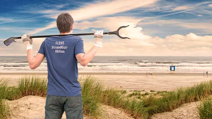 StrandGut Mann mit Rechen und Strand im Hintergrund