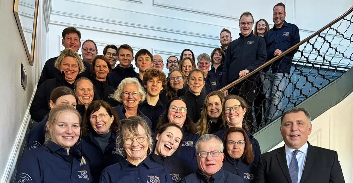 Gruppenbild der Flensburger Stadtbläser auf einer Treppe.
