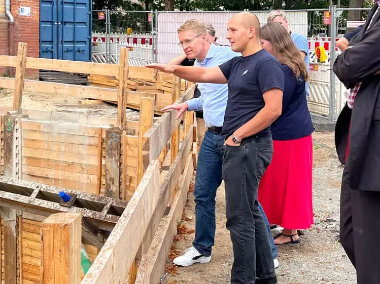 Brauer Enes Erisgen zeigt SH-Ministerpräsident Daniel Günther und seinem Team die Baustelle des neuen Suhauses.