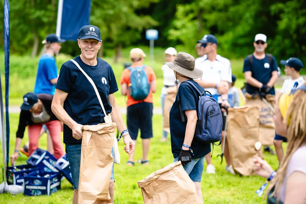 Freiwillige bei FLENS StrandGut Event beim Müllsammeln.