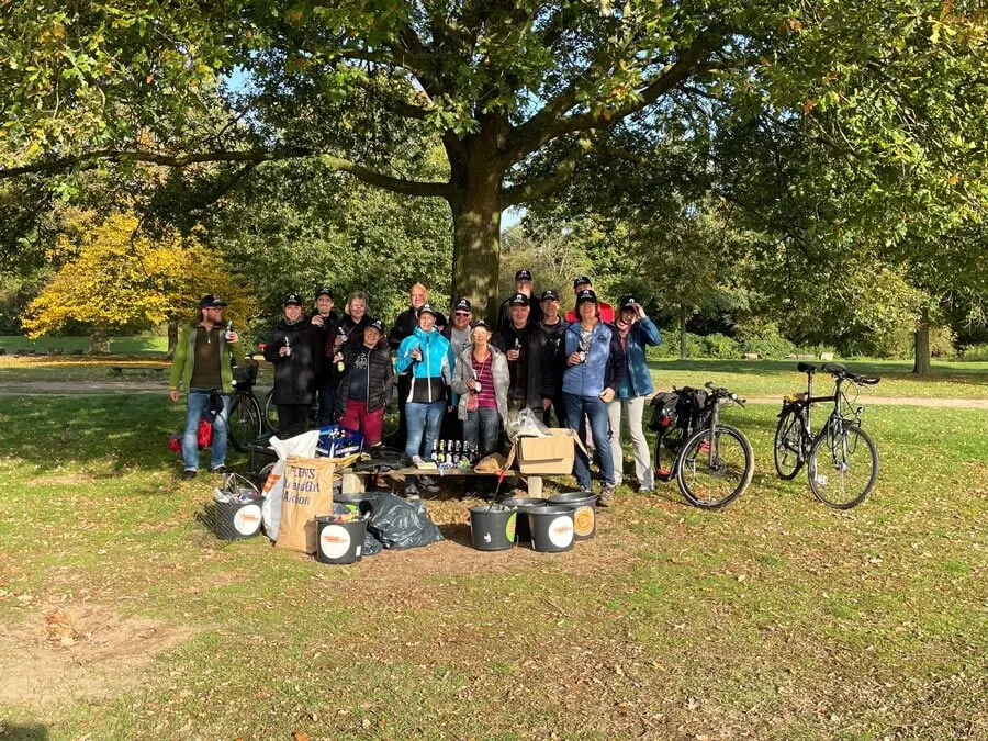 Gruppe von Freiwilligen bei einer FLENS StrandGut Aktion im Grünen mit Fahrrädern.