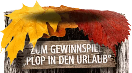 Herbstlicher Holzpoller mit Schild vorne: "ZUM GEWINNSPIEL: "PLOP IN DEN URLAUB"."