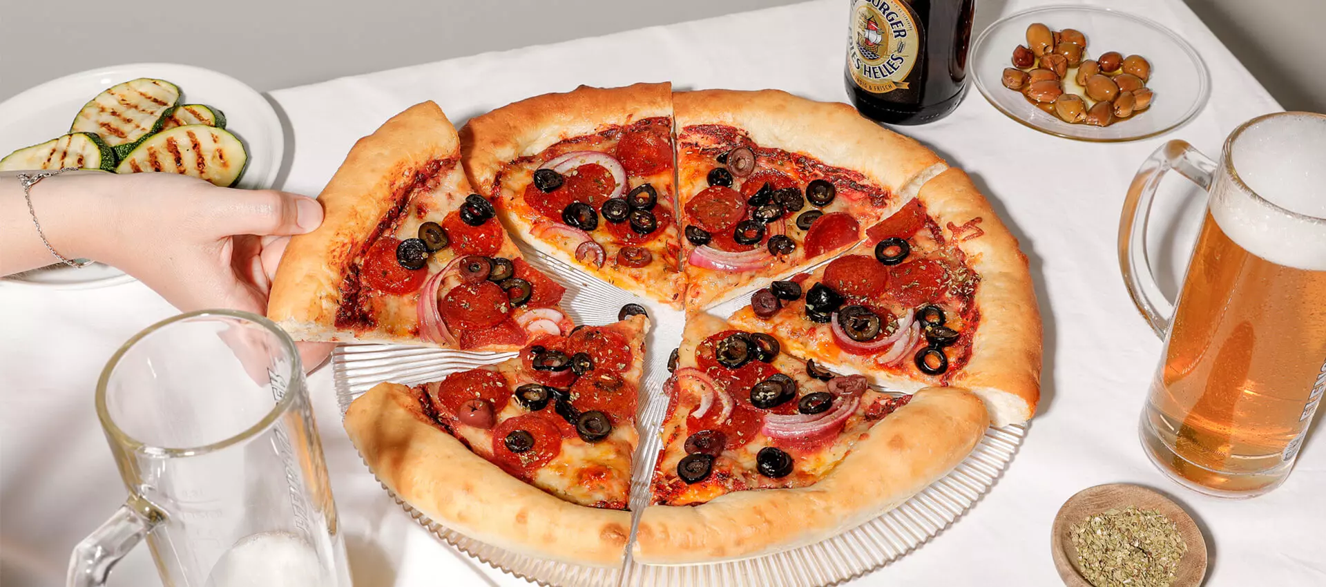 Peperoni Pizza, mit Oliven und zwei FLENS Edles Helles.