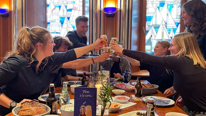 Menschen, die beim Essen anstoßen, bei der Brauereibesichtigung.