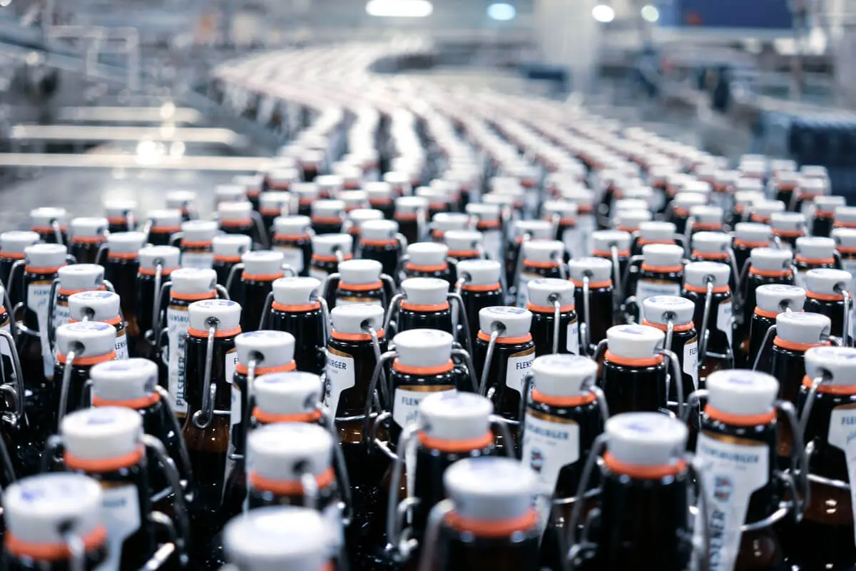 Many swing-top bottles on a conveyor belt during bottling.