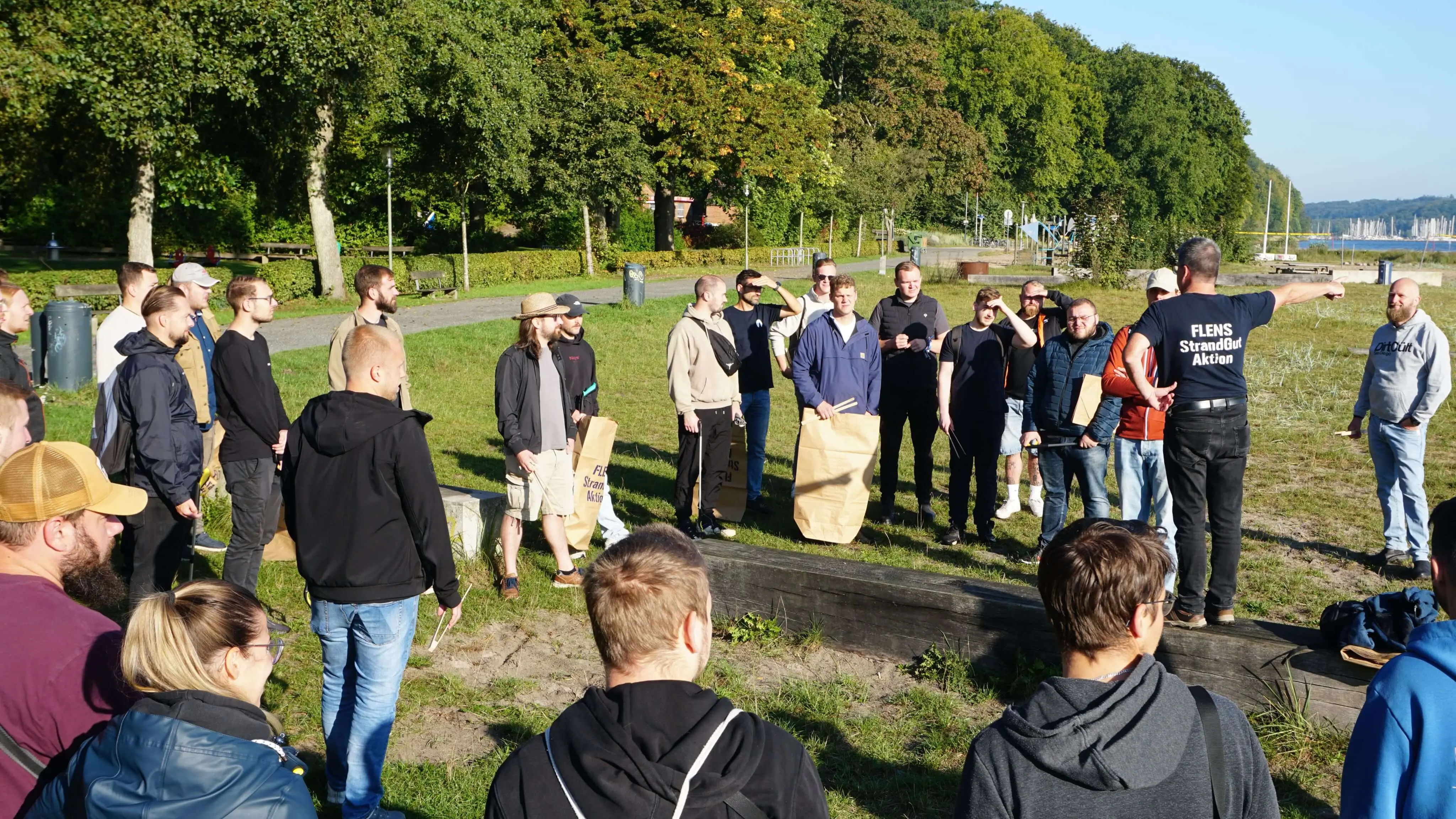 Gruppe von Menschen bei einer FLENS StrandGut Aktivität an der Küste.