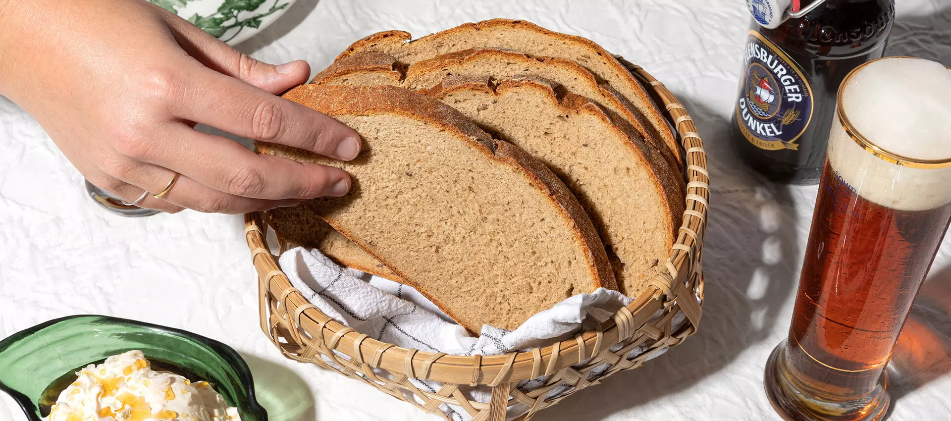 Bierbrot in einem Korb zusammen mit einem FLENS Dunkel in der Flache und im Glas.