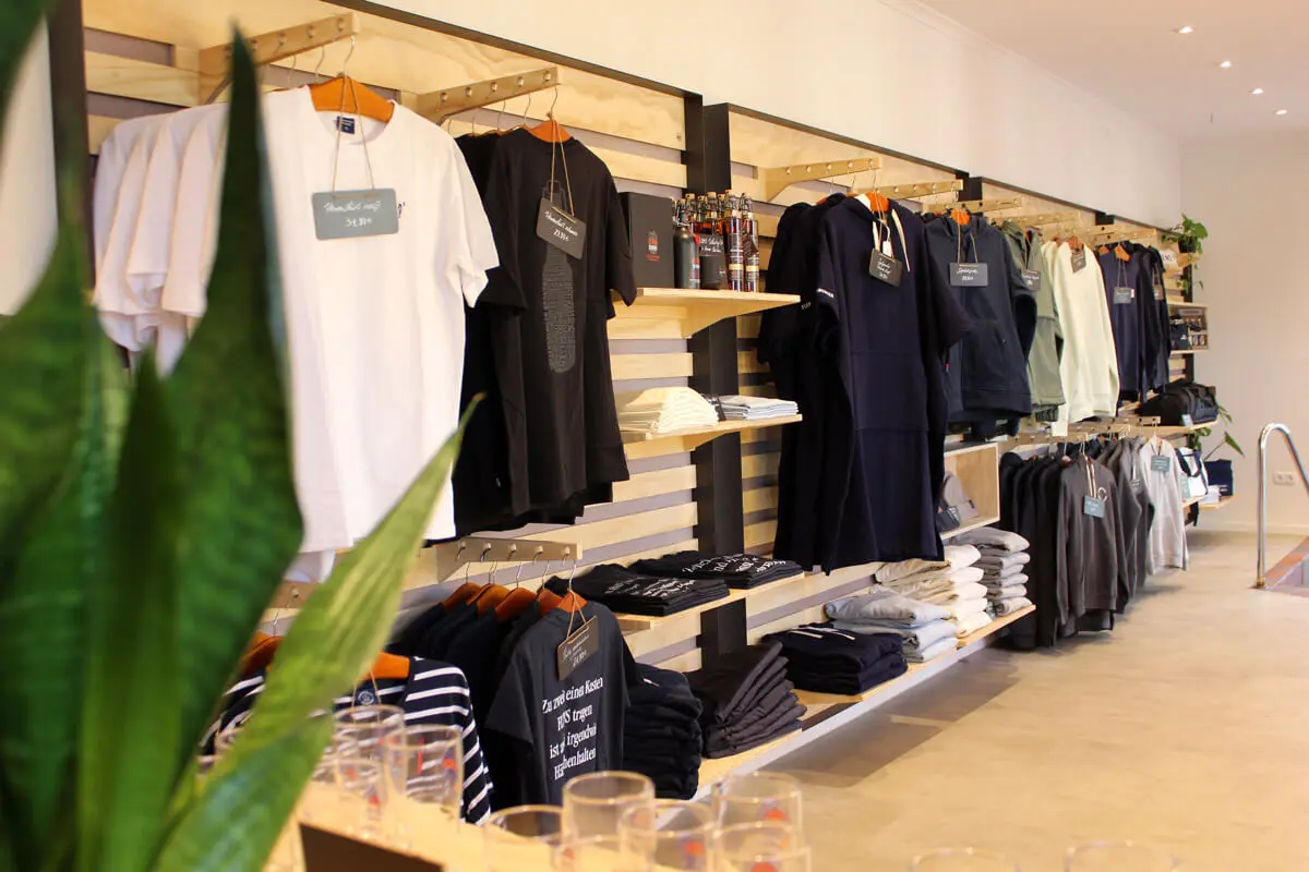 Innenansicht des Plop-Shops mit vielen Klamotten und weiterem FLENS Merch.