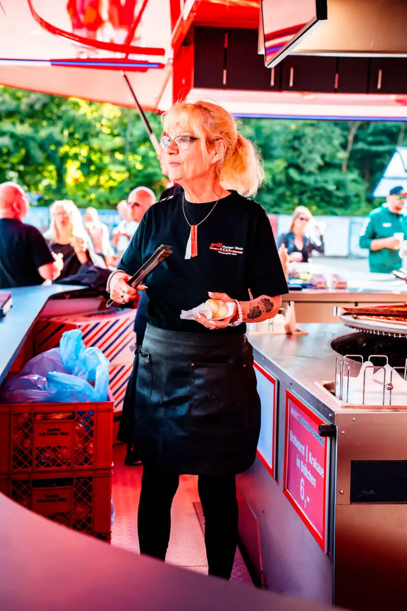 Servicekraft auf dem FLENS Festival 2025 am Schwenkgrill.