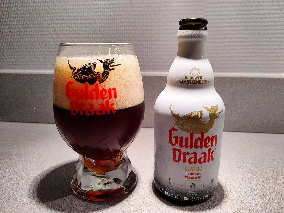 Eine Flasche Gulden Draak Bier, daneben das Bier in einem Glas eingeschenkt.