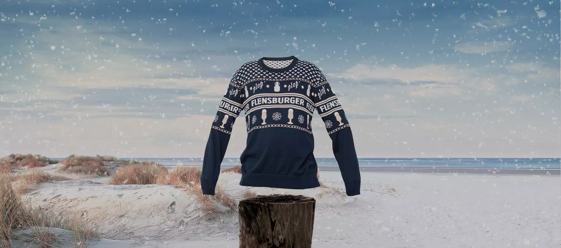 Weihnachtspullover der Flensburger Brauerei am schneienden Strand.