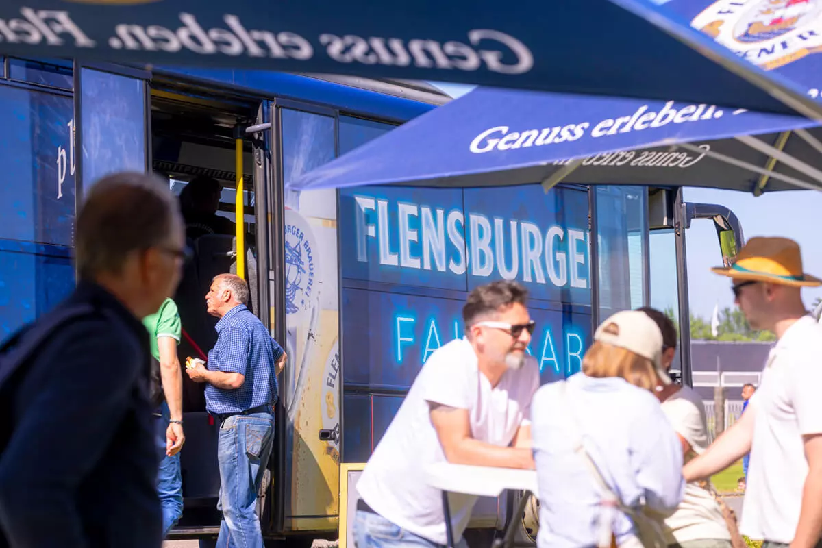 Ein Fußballmannschaft läuft aufs Feld, im Hintergrund die Flensburger Fahrbar.