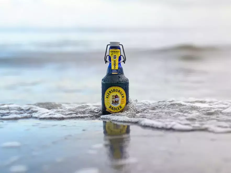 Blaue Flasche Flensburger Radler in der Brandung